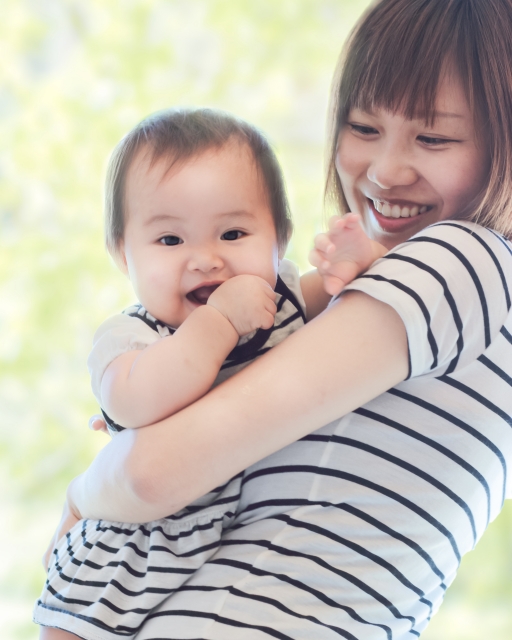 赤ちゃんを抱っこする、幸せそうな女性